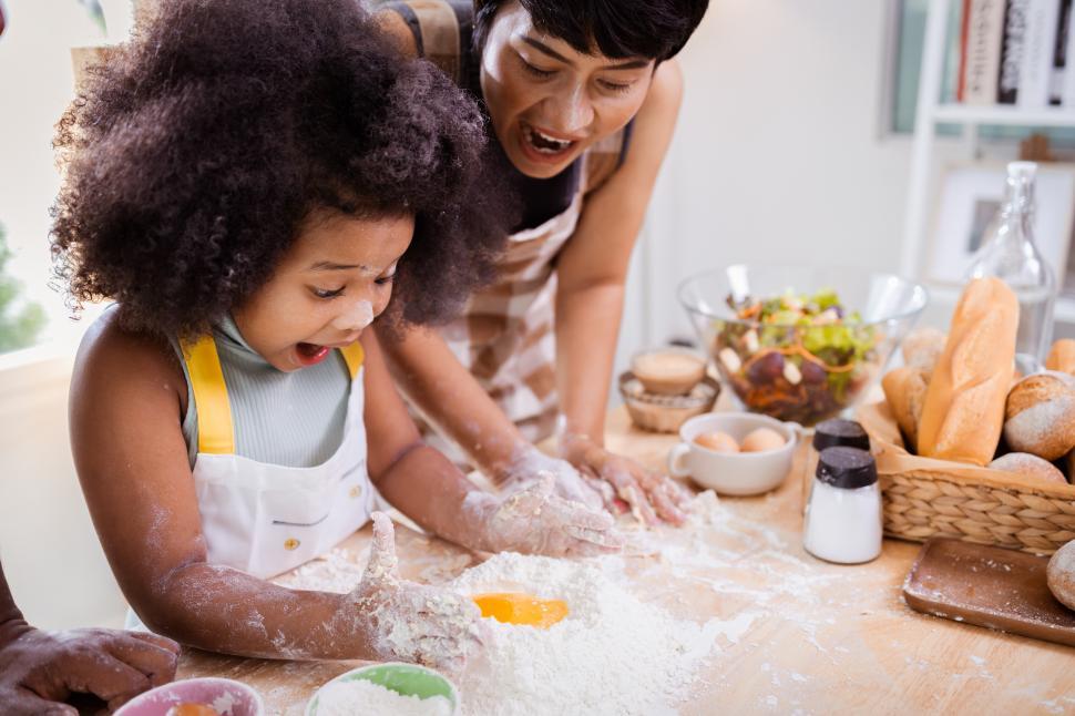 Free Image of Girl loves baking - excited kid mixing egg and flour 