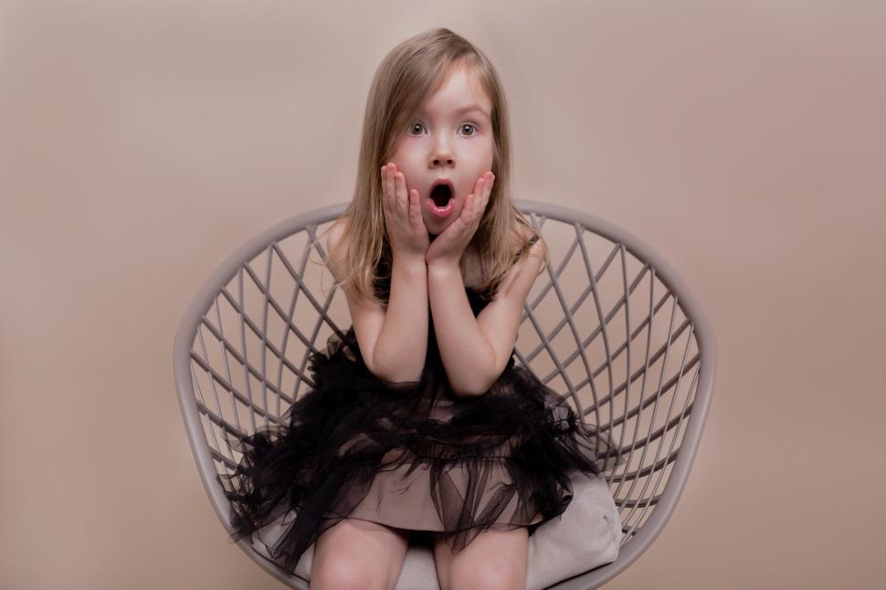 Free Image of Expressive little charming girl sitting on isolated background 