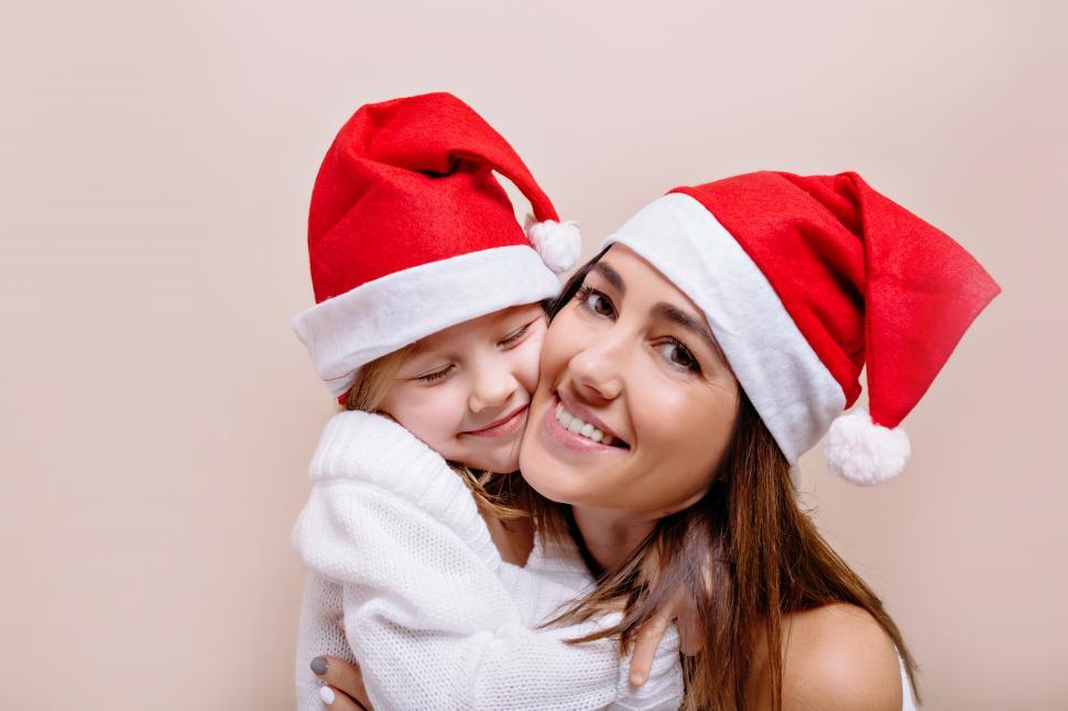 Free Image of Happy, smiling funny mother and daughter are posing int santa caps 