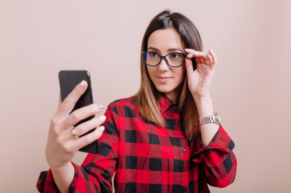 Free Image of Stylish woman wears glasses making selfie on smartphone  