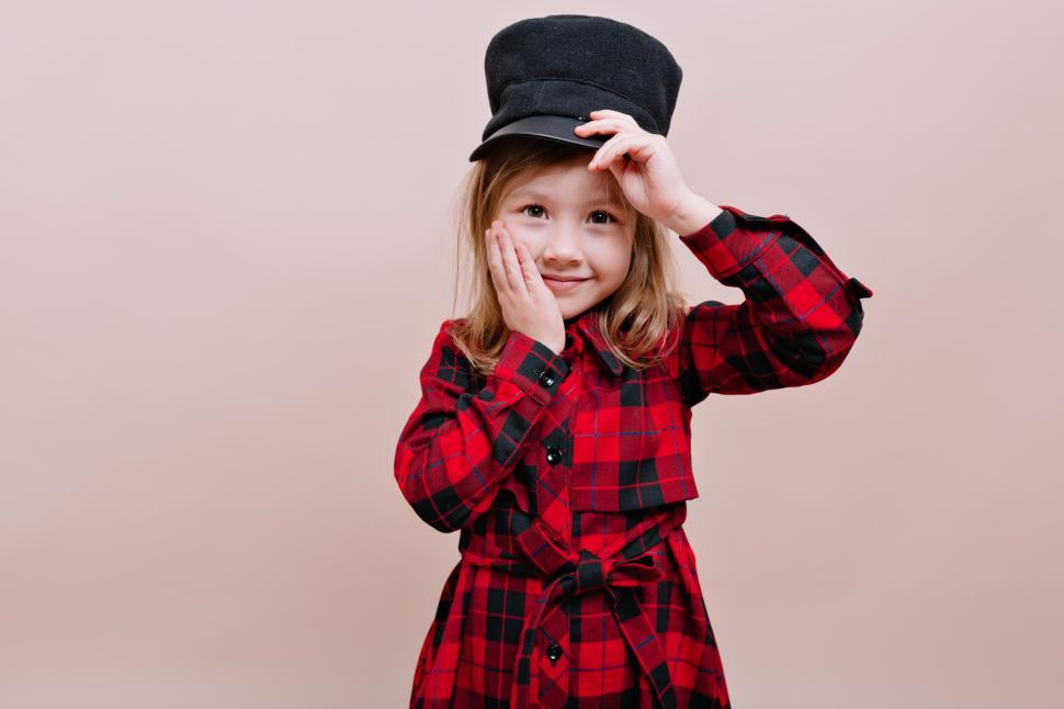 Free Image of Portrait of cute little girl wears stylish black cap and checkered shirt 