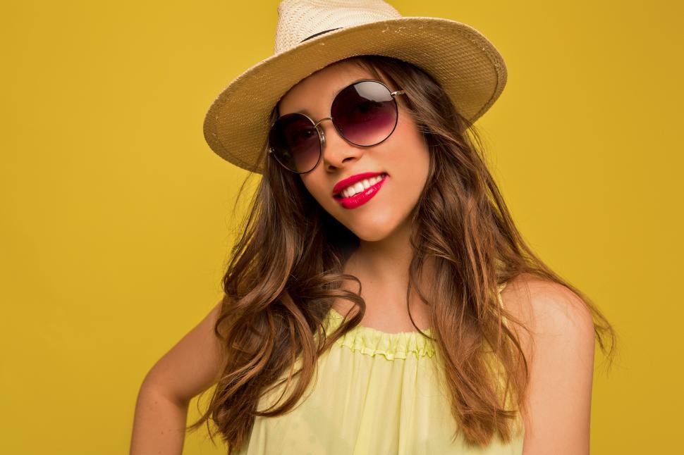 Free Image of Close-up indoor portrait of young elegant woman in hat and sunglasses 