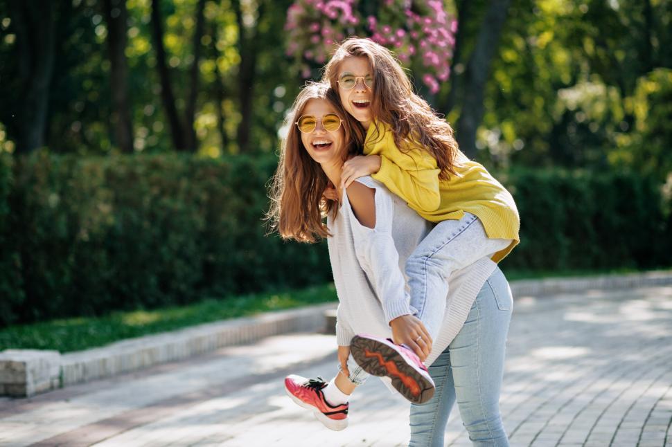Free Image of Smiling women in bright glasses giving piggyback ride 