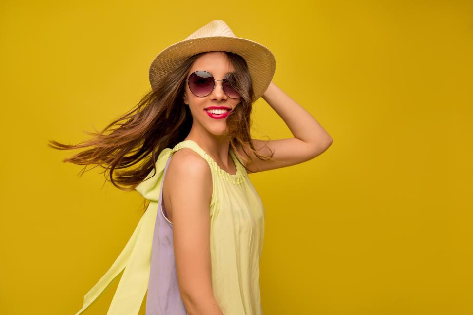Free Image of Smiling girl with wonderful smile posing in front of yellow backdrop 