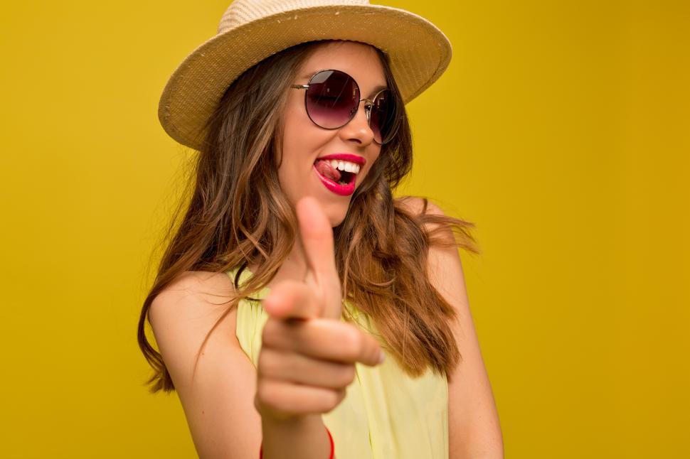 Free Image of Pretty european woman winking at camera and pointing finger 