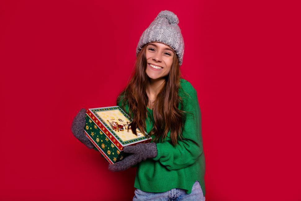 Free Image of Happy new year party time of smiling young woman holding present 