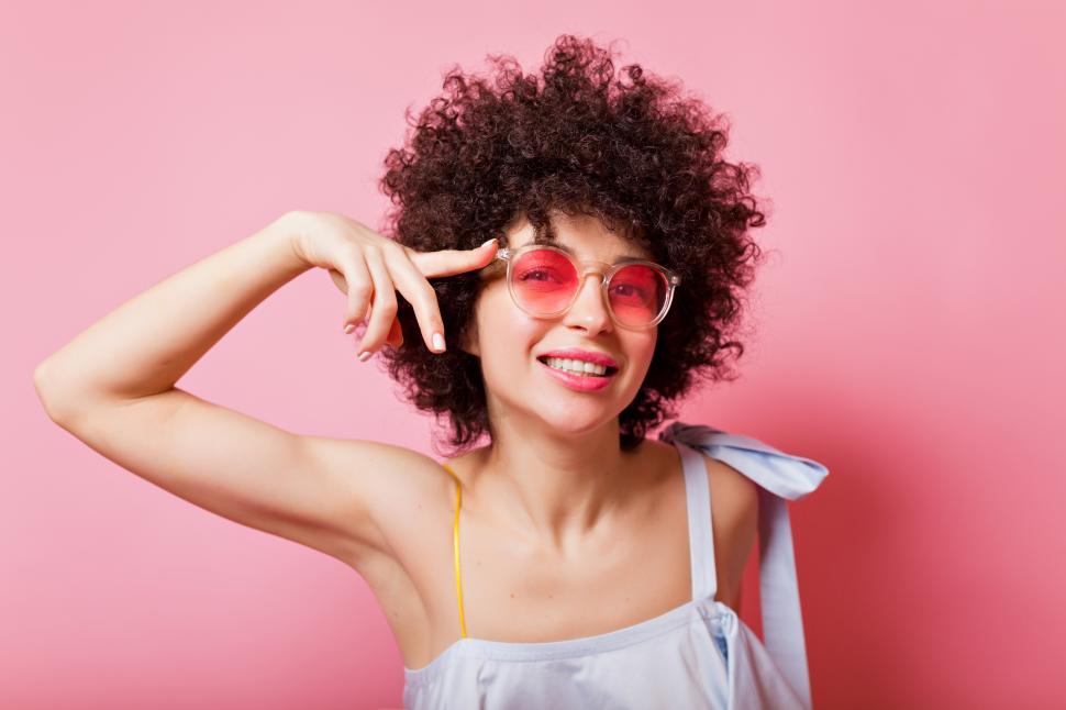 Free Image of Stylish girl with short ringlets wears pink sunglasses 
