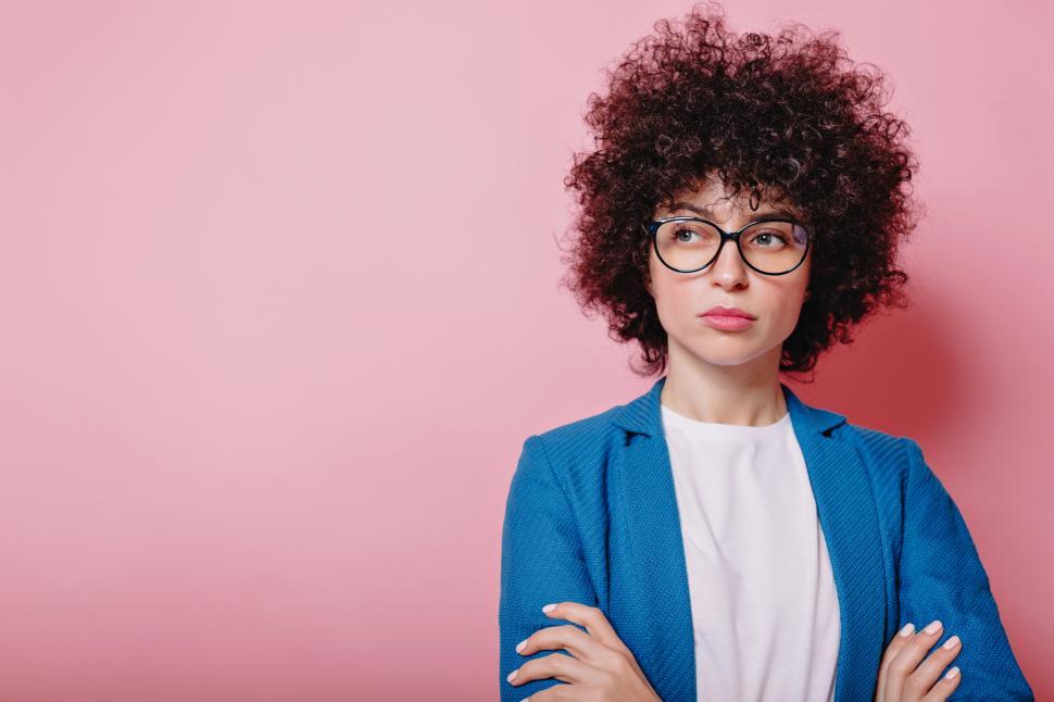 Download Free Stock Photo of Modern businesswoman with short curly hair dressed jacket and glasses poses on isolated background 