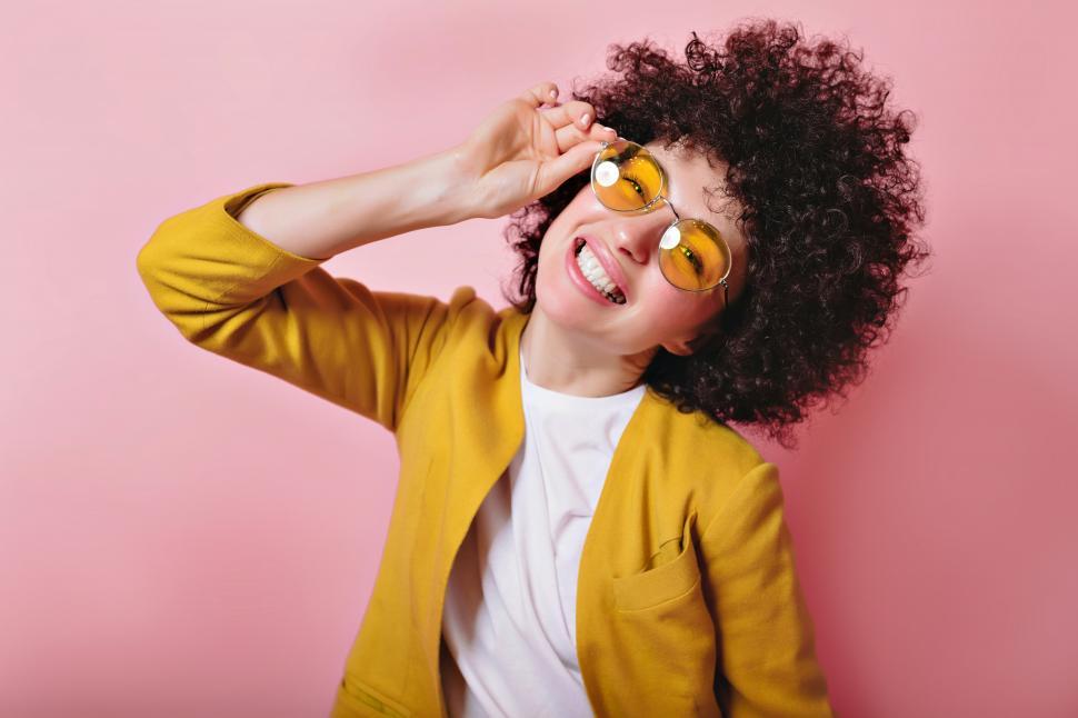 Free Image of Portrait of charming lady with stylish short curly hair and yellow lens glasses 