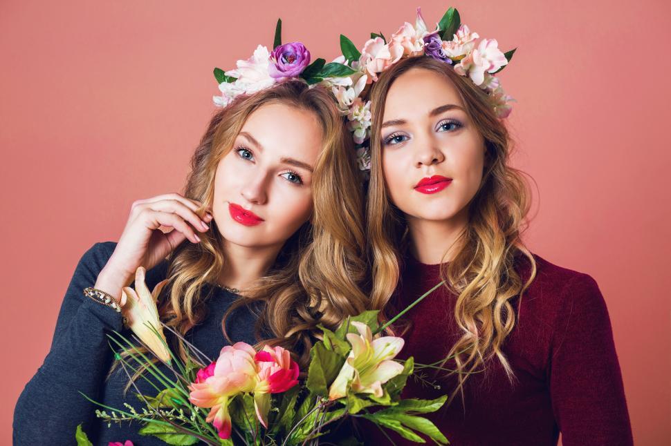Free Image of Two young pretty blonde women in spring flowers 
