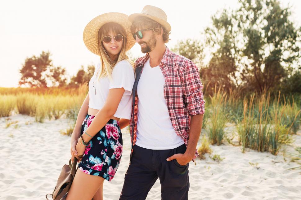 Free Image of Outdoor lifestyle portrait of young beautiful stylish couple in summer on the beach 