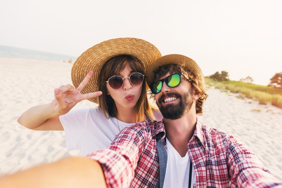 Download Free Stock Photo of Traveling couple in love taking a selfie on phone at the beach 