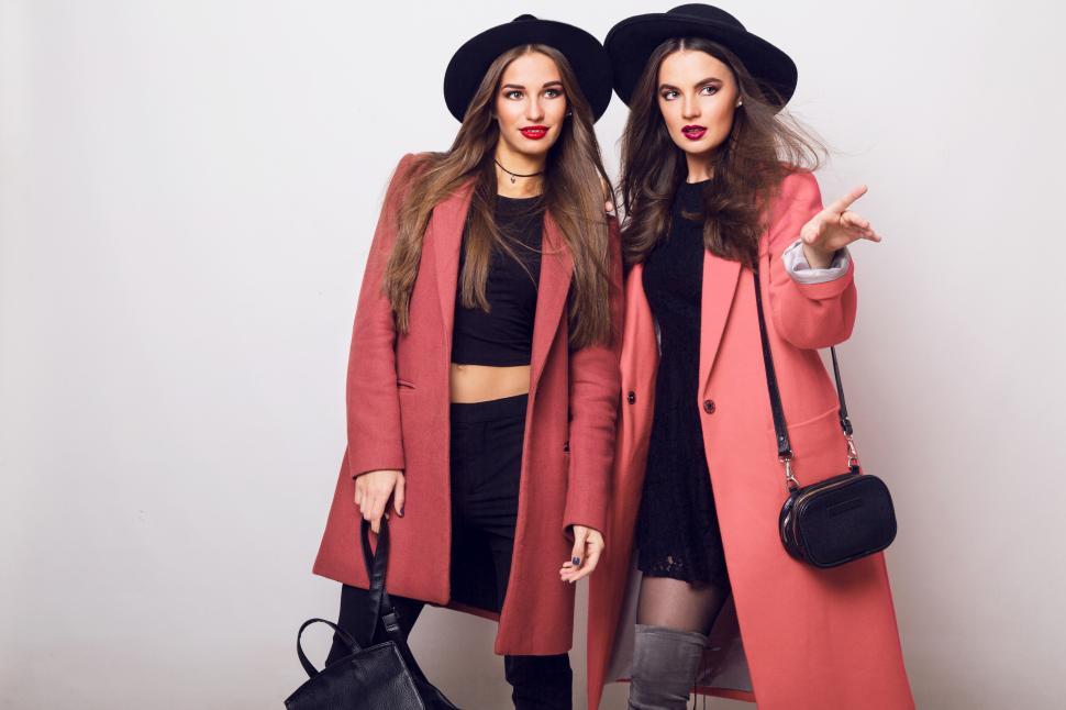 Free Image of Two attractive young models in casual spring outfit, pink coats 