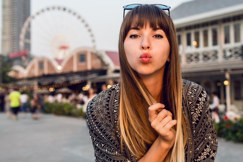 Free Image of Young travel woman sending kisses, having great time on riverfront of Bangkok 