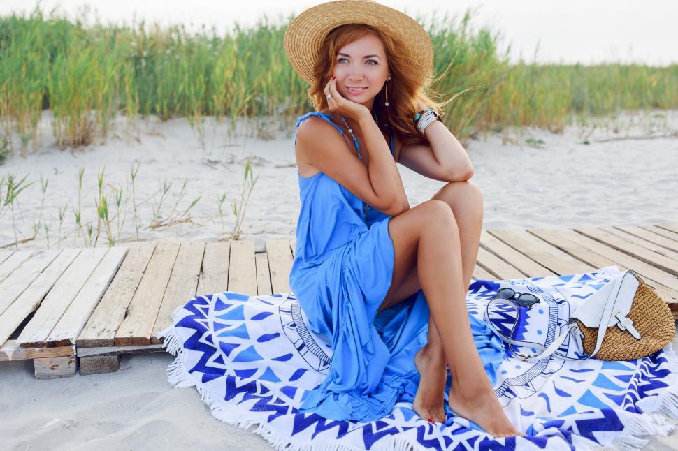 Free Image of Pretty slim woman with long red hairs in straw hat on the beach 