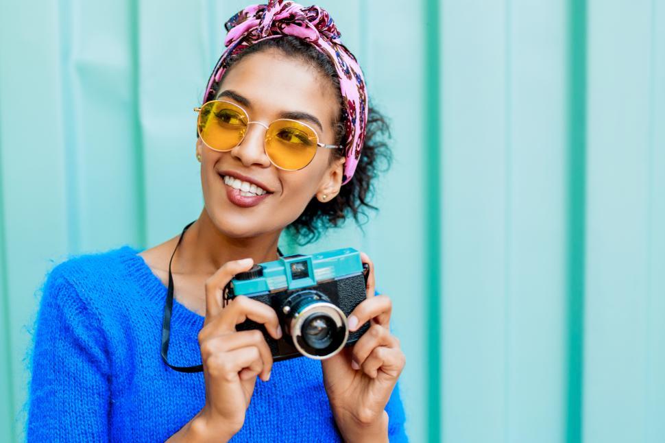 Free Image of Girl with cute hairstyle holding retro camera 