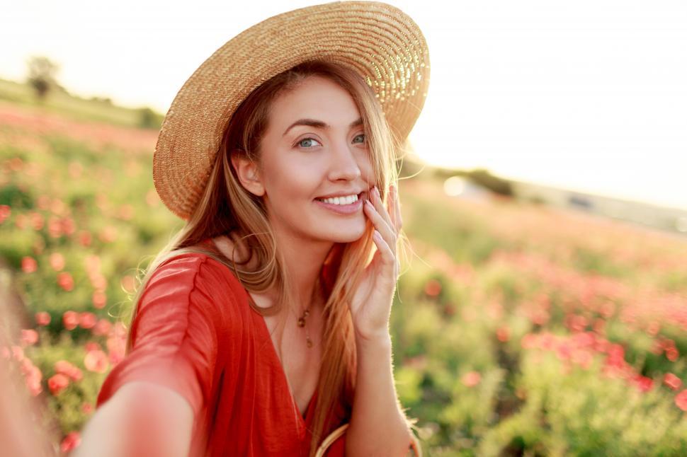 Free Image of Playful smiling woman posing in poppy field 