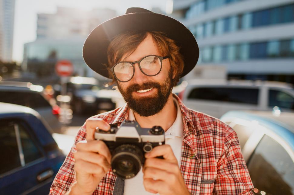 Free Image of Portrait of smiling Hipster man using retro film camera 