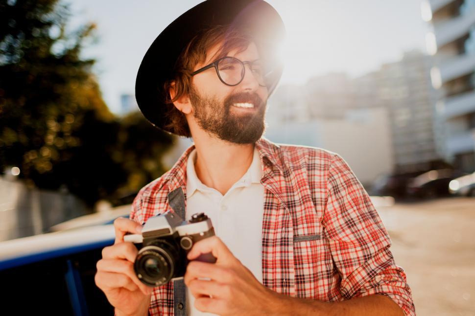 Free Image of Excited man with beard with interesting using retro film camera 