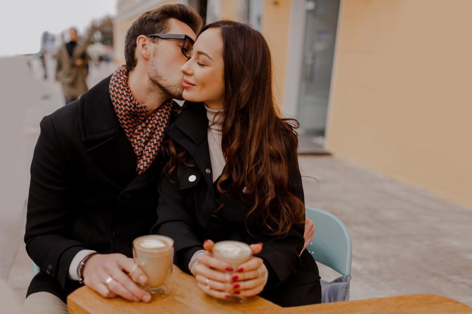 Free Image of Man and his girlfriend  hugging and enjoying hot beverage 
