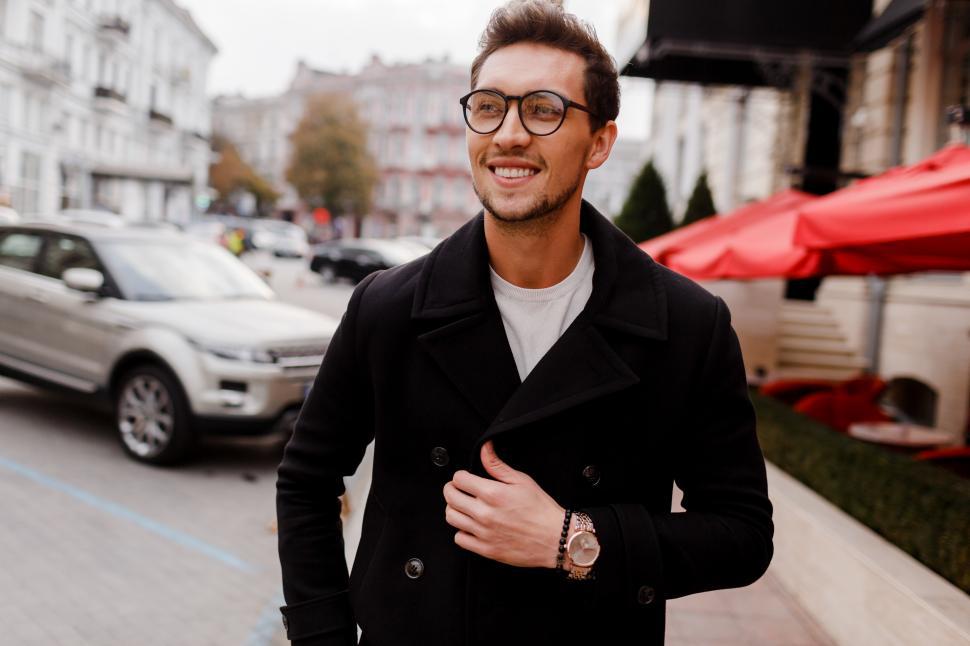 Free Image of Young man in glasses wearing autumn  clothes  walking  on  the street 