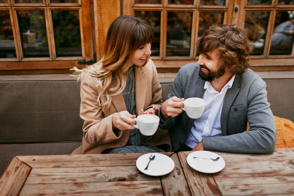 Free Image of Elegant couple sitting in cafe with cappuccino. 
