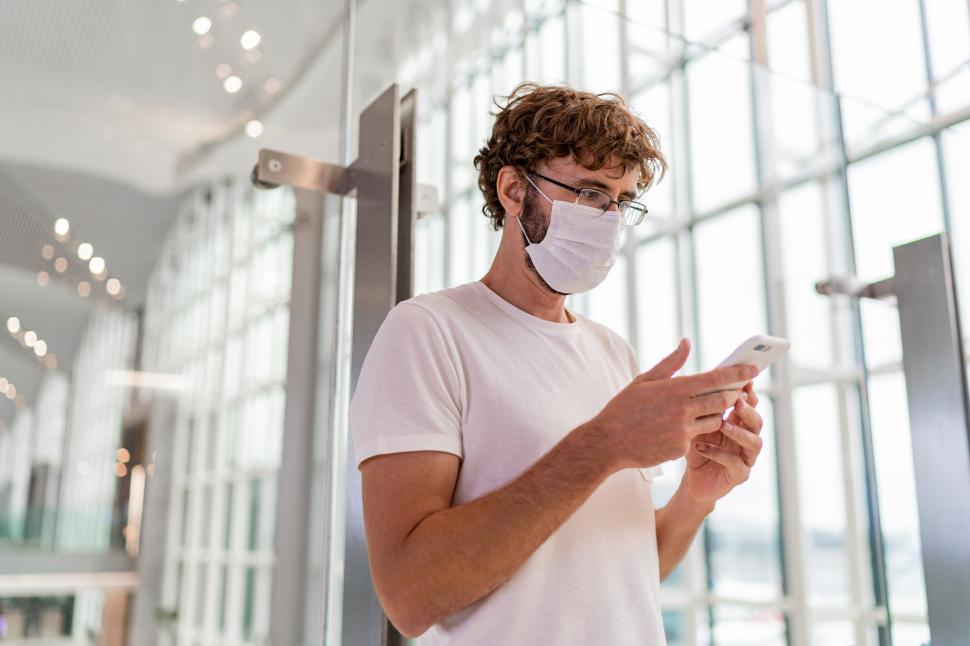 Free Image of Man wearing face protective medical mask using smartphone 