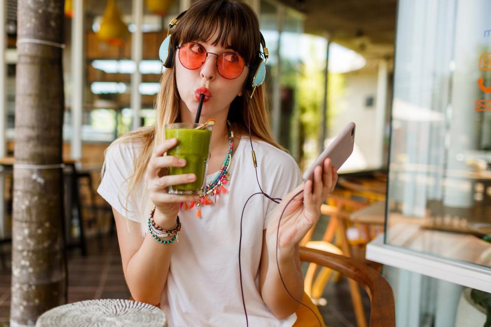Free Image of Stylish woman in pink glasses enjoying green healthy smoothie 