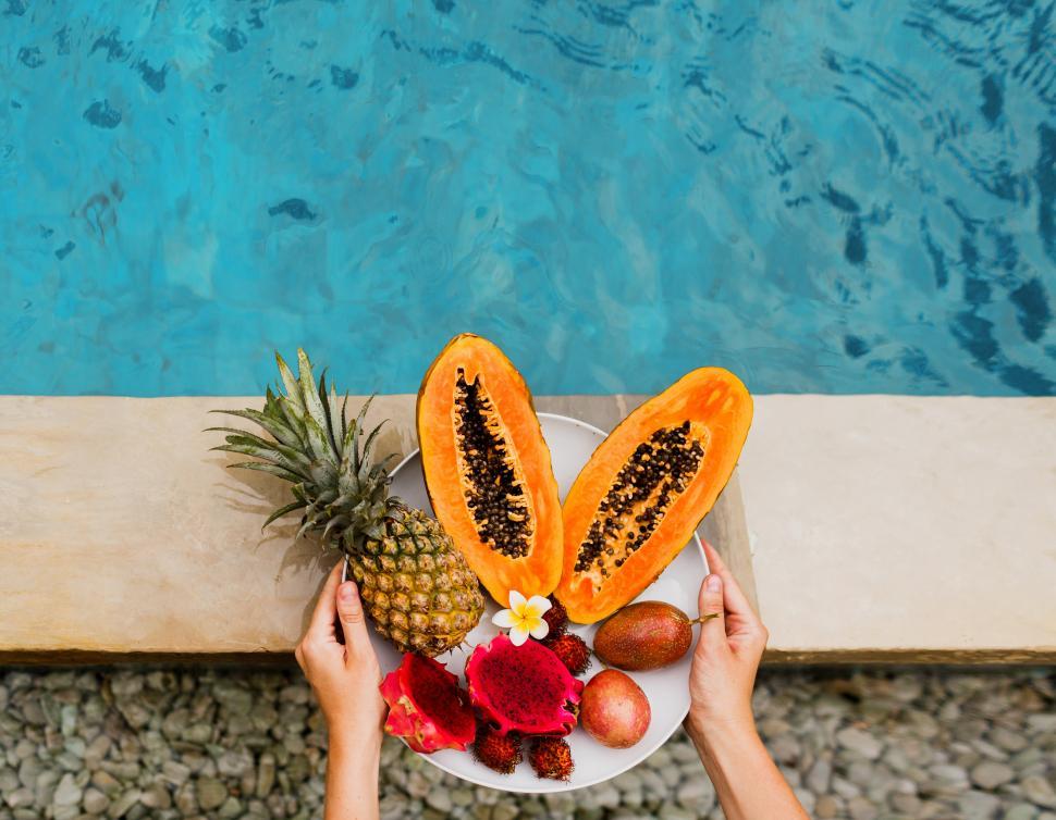 Free Image of Plate of tasty tropical exotic fruits on the edge of pool 