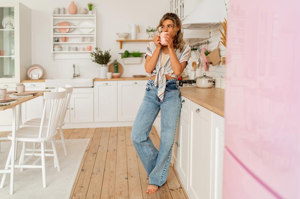 Free Image of Woman enjoying cozy morning on her stylish kitchen while drinking hot tea 