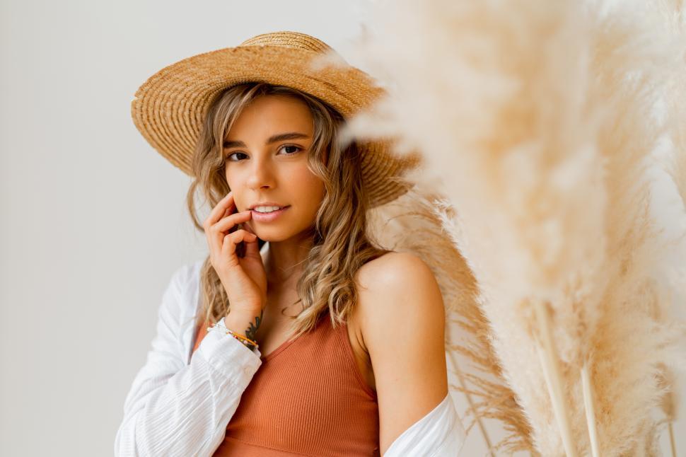 Free Image of Portrait of attractive woman in summer outfit with straw hat 