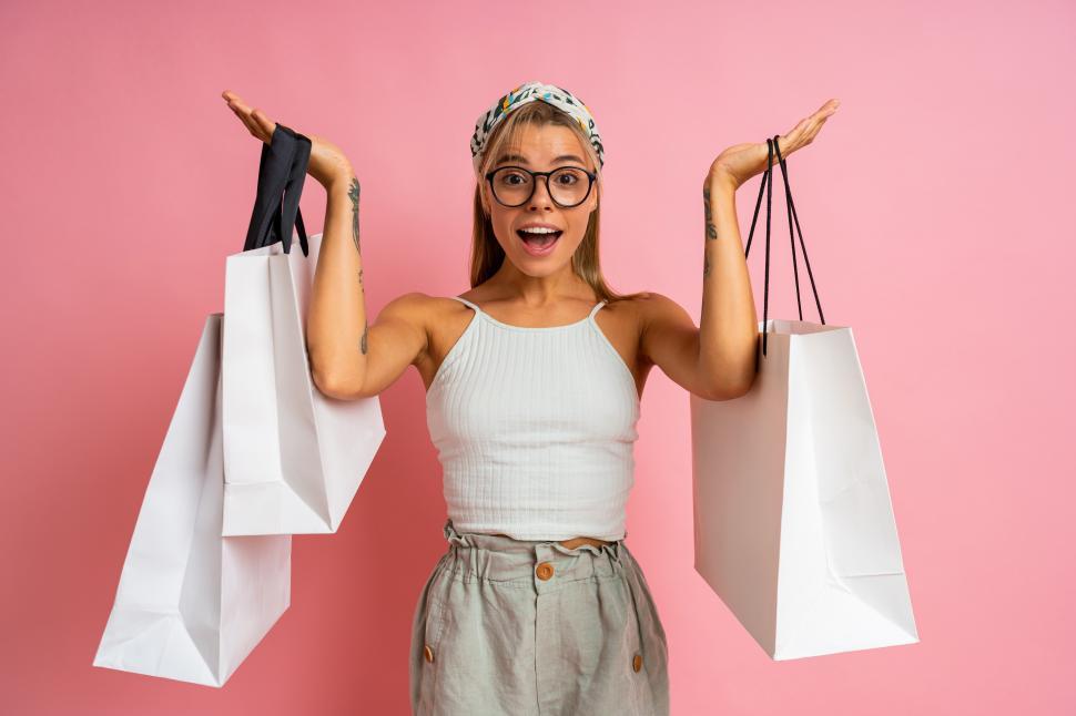 Free Image of Playful blond woman white shopping bags 