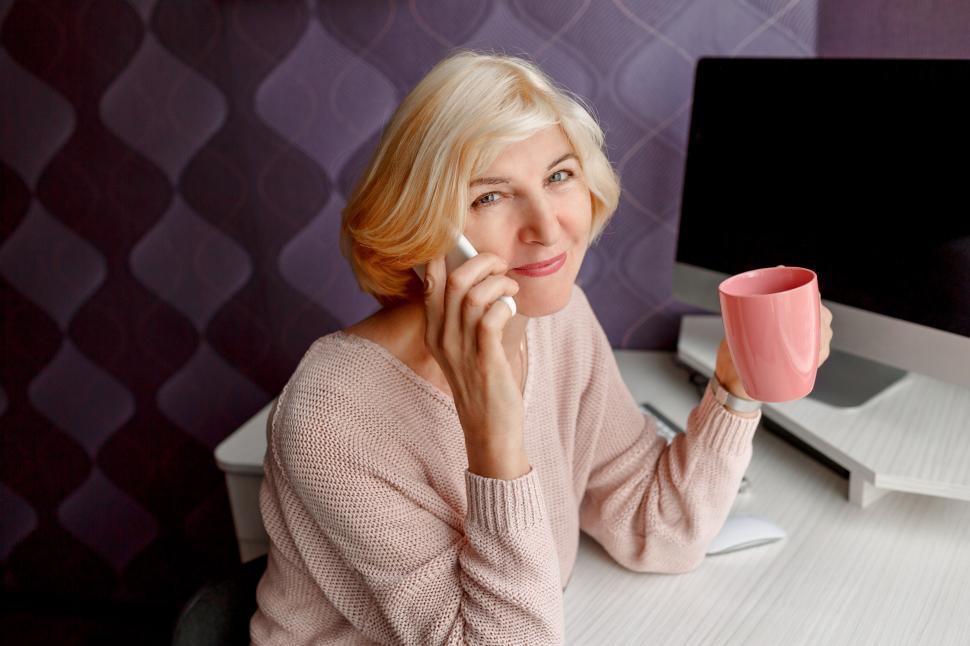 Free Image of Smiling mature woman using mobile phone  