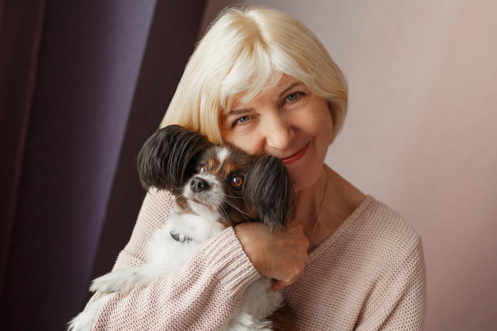 Free Image of Mature woman lovingly hugging pet dog 