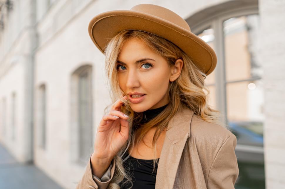 Free Image of Stylish blond woman with wavy hair in beige hat and casual suit 