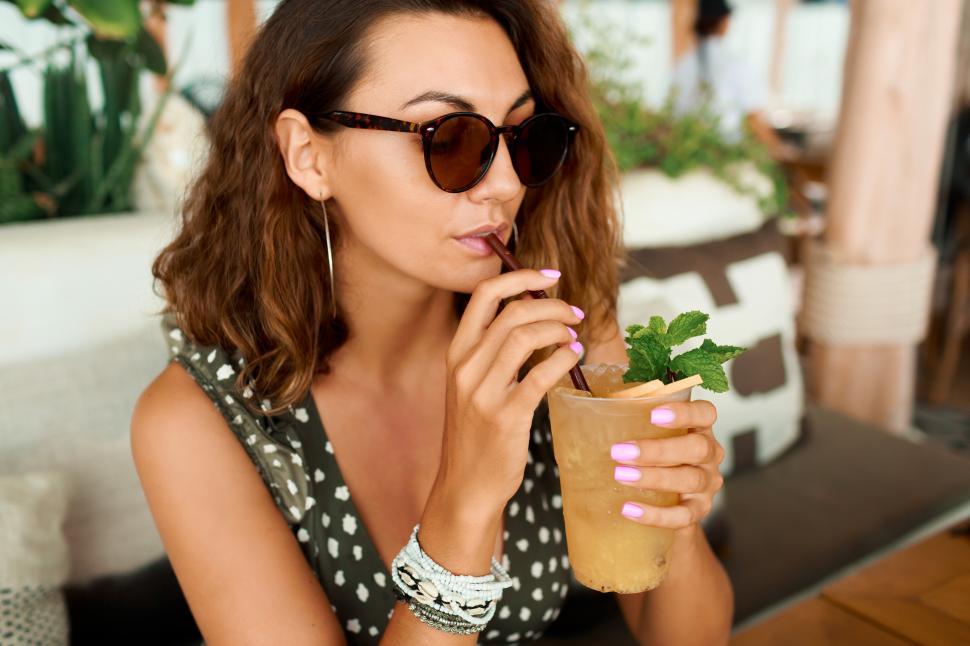 Free Image of Woman with wavy hair drinking cocktail in cafe 