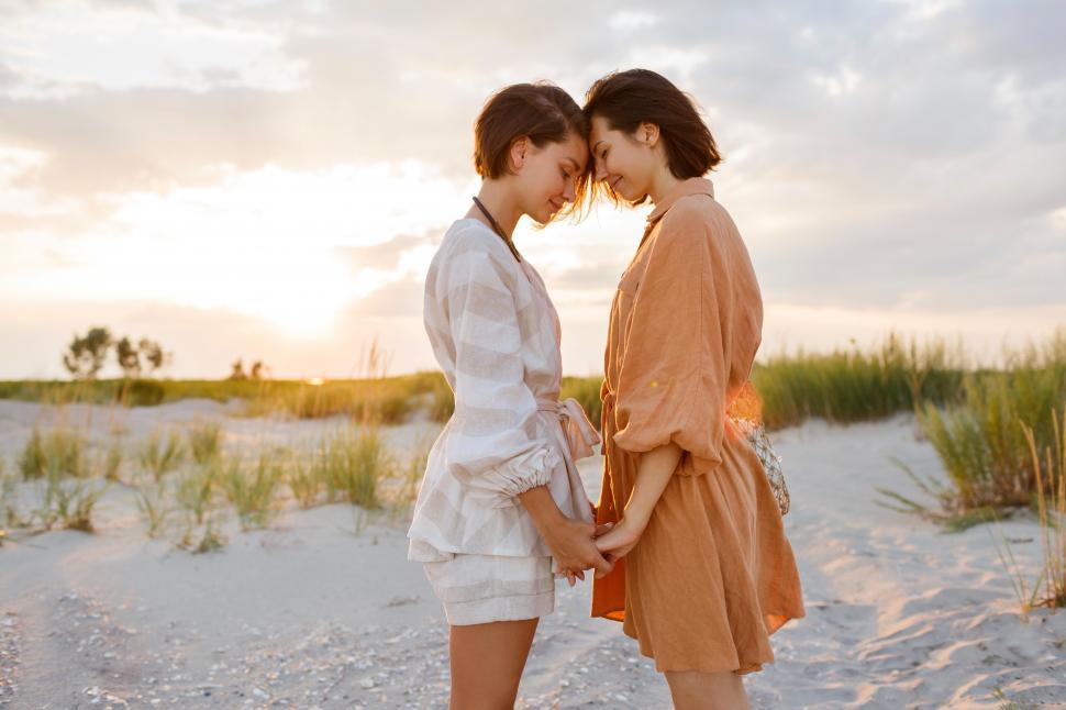 Download Free Stock Photo of Two affectionate women standing face to face on beach  
