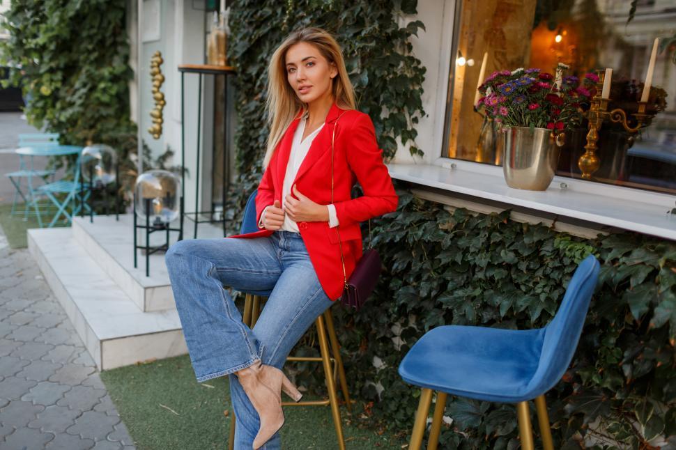 Free Image of Woman in red jacket resting in street cafe 