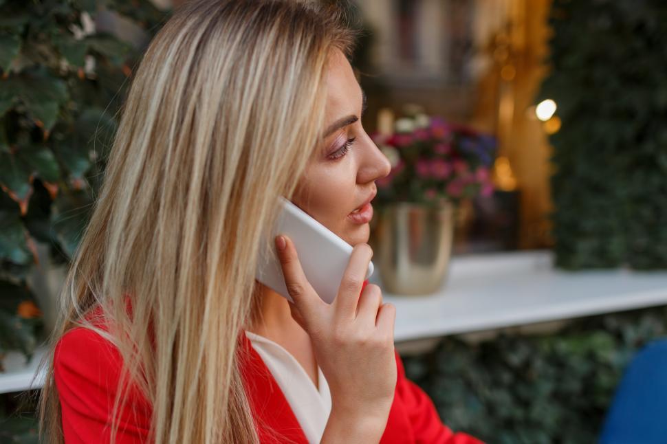 Free Image of Confident business woman in red jacket talking by mobile phone 