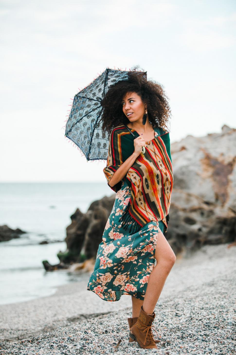 Free Image of black girl in an elegant dress in the shore with an umbrella 
