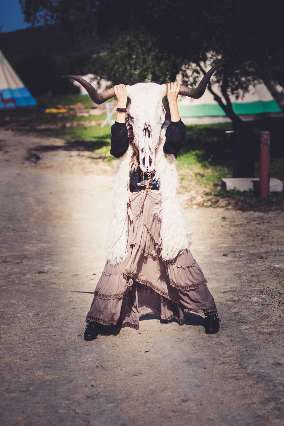 Free Image of A girl behind a cow skull 