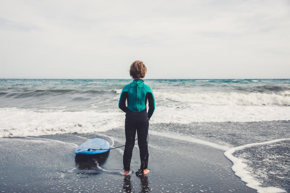 Free Image of a young kid with surfboard at the beach 