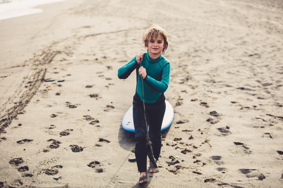 Free Image of Surfer boy taking a surf lesson and going to the beach 