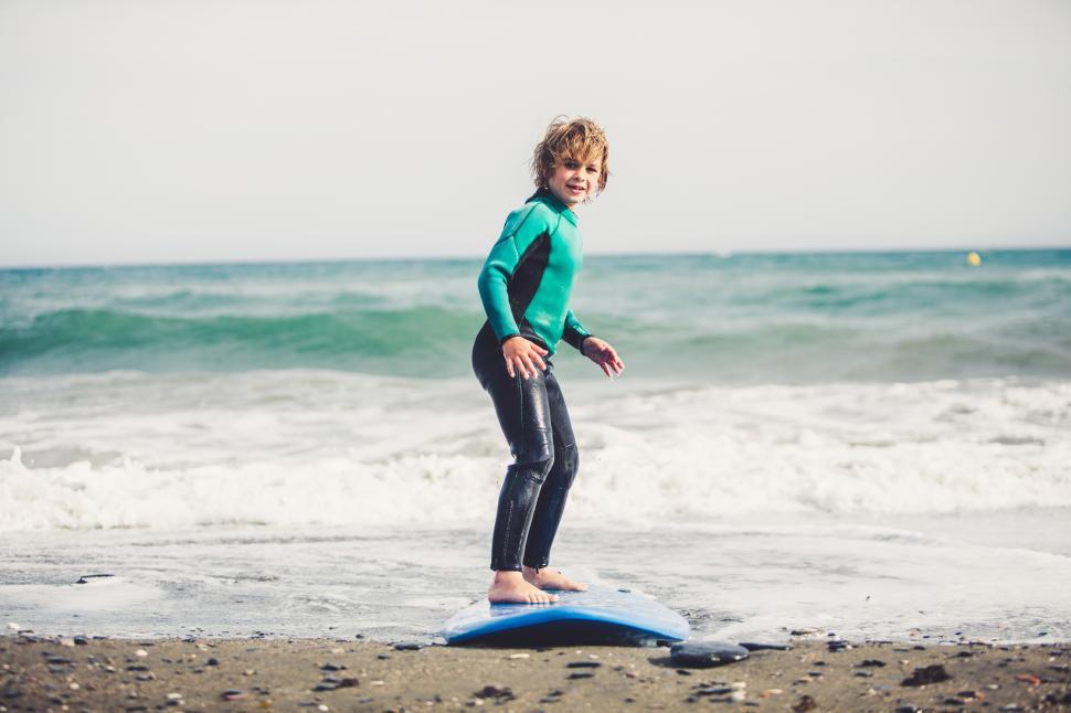Free Image of a young kid learning on a surfboard 