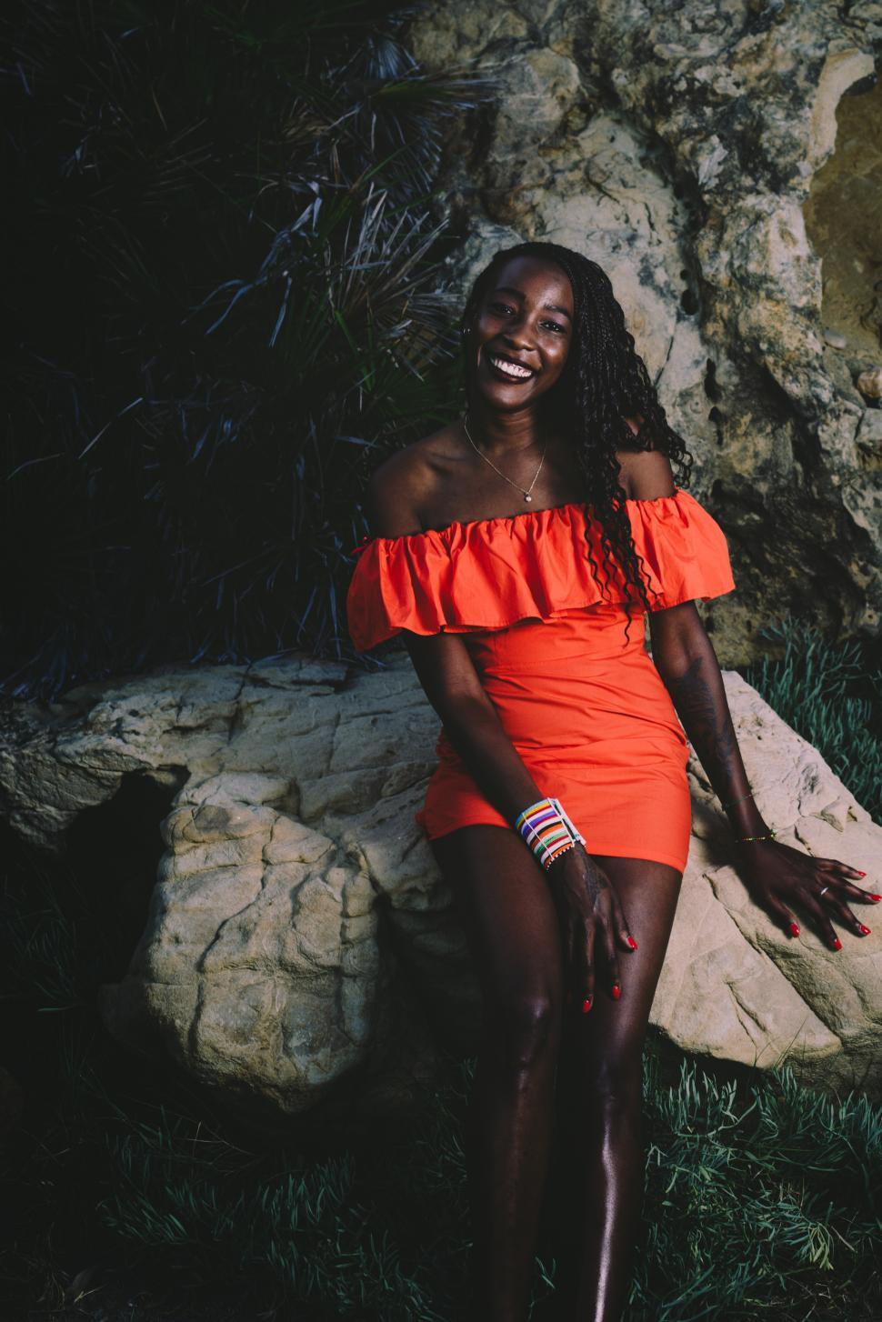 Free Image of Portrait of young black woman wearing a red dress at the beach 