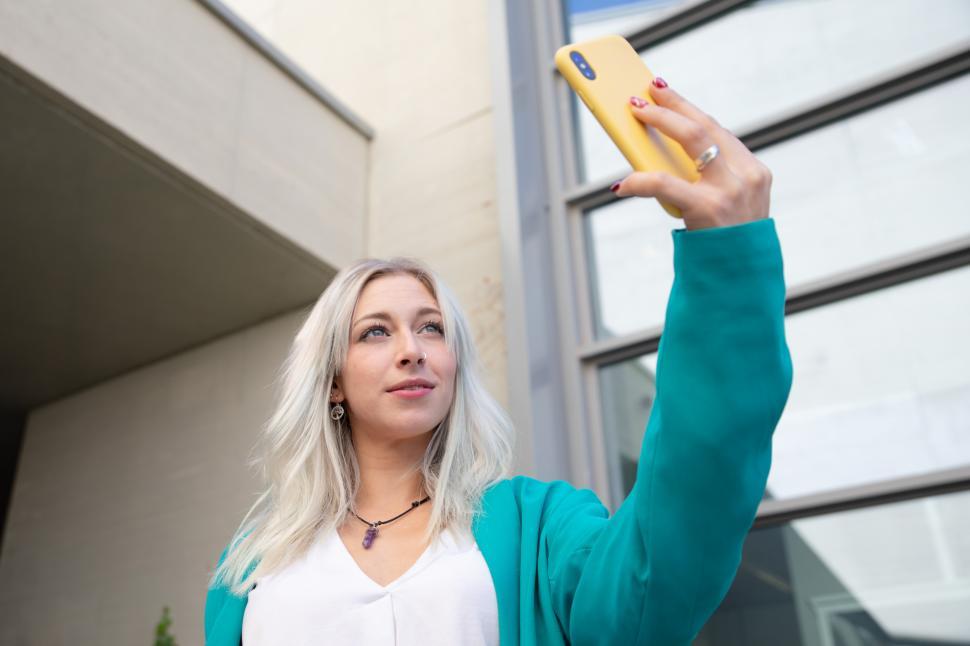 Free Image of a professional young woman using a smartphone. Selfie. 
