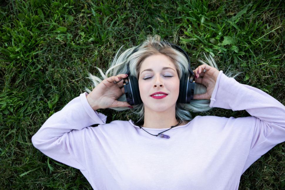 Free Image of a young blonde woman chilling and enjoying music 