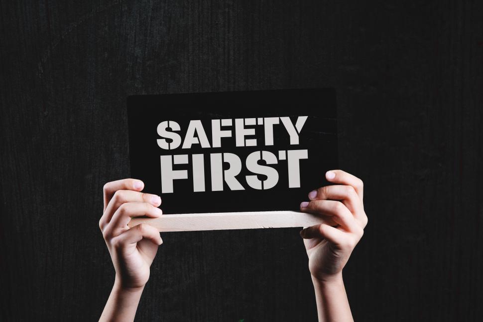 Free Image of a hand holding a black placard with the message SAFETY FIRST 