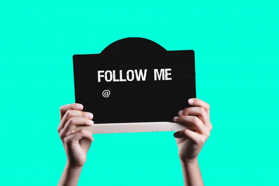 Free Image of Hand holding FOLLOW ME sign 