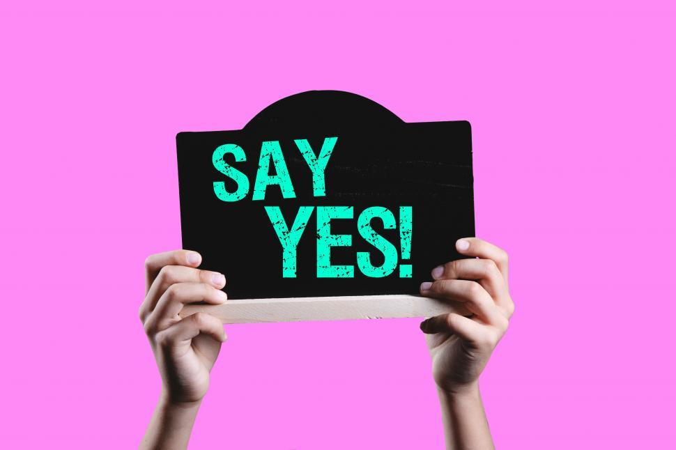 Free Image of SAY YES sign held in the air 